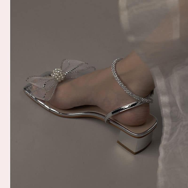 Sandal phối hoa nơ trắng bóng với thiết kế đầu mũi vuông phong cách tiểu thư
