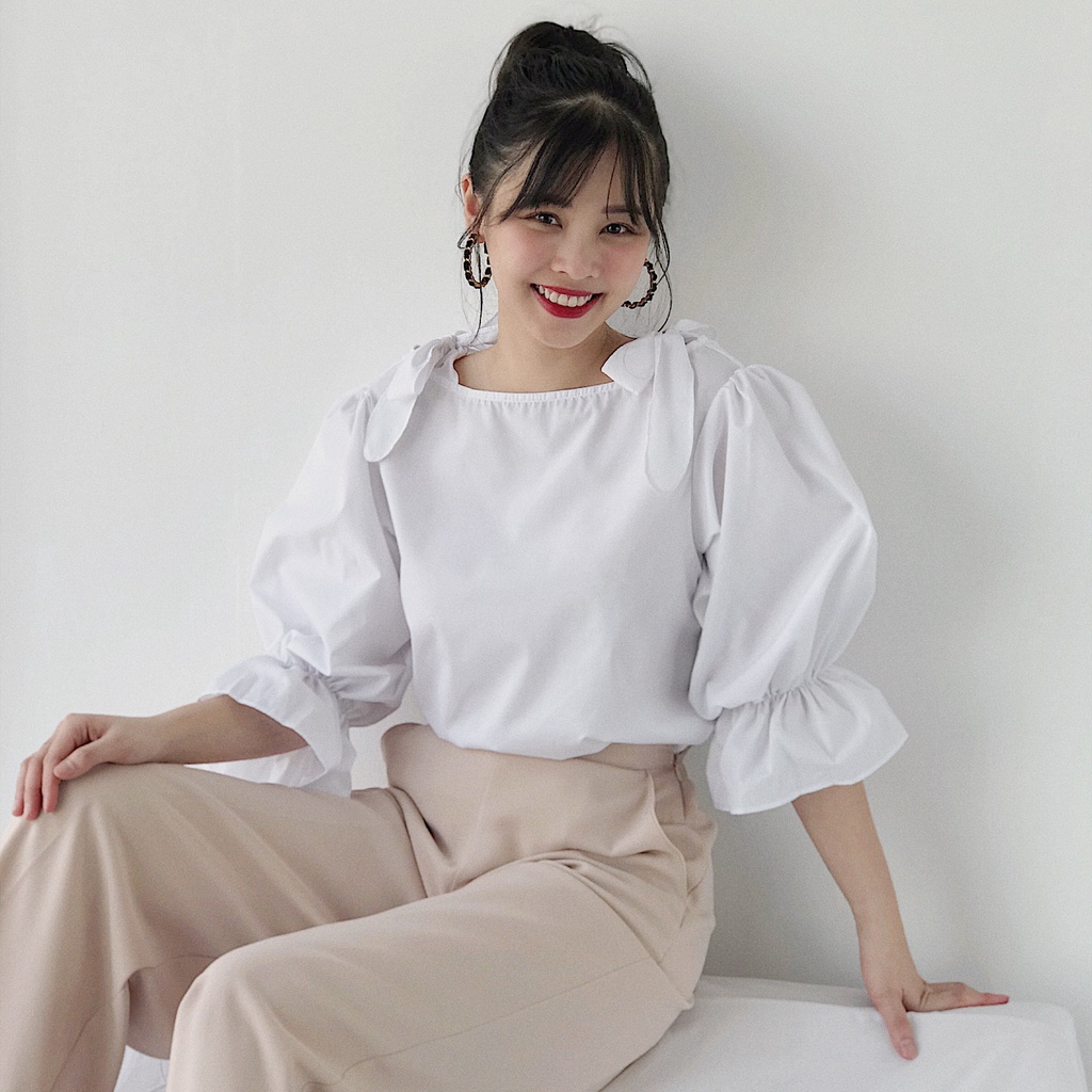 KIOBI - Áo kiểu Audrey form suông, cổ thuyền, tay phồng bo thun lai bèo, thắt nơ trên vai,vải kate silk trắng - KIA1973T