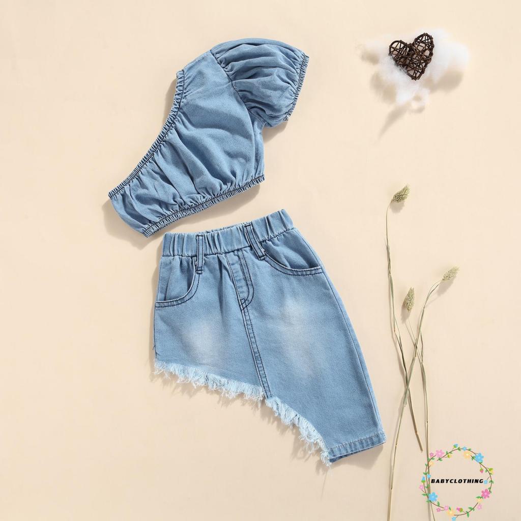 Set áo kiểu croptop denim tay ngắn hở một bên vai và chân váy denim vạt lệch màu sắc thời trang dành cho bé gái