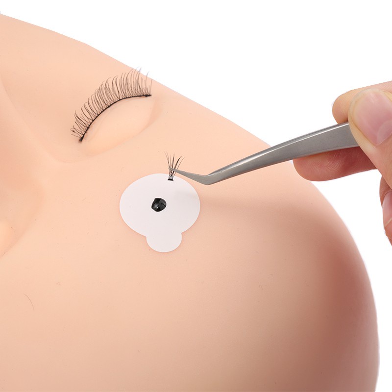 Hàng trăm sợi lông mi mới được quấn bằng một thanh gỗ, phần mở rộng của dụng cụ bằng đá dính