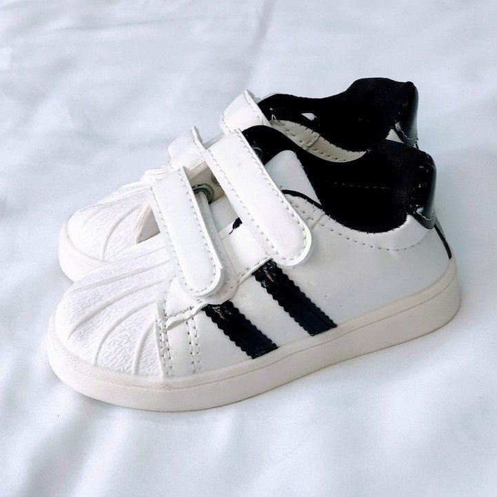 Giày thể thao Adidas màu trắng dành cho bé trai và bé gái có sọc đen hai bên. Giày thể thao trẻ em (095150)