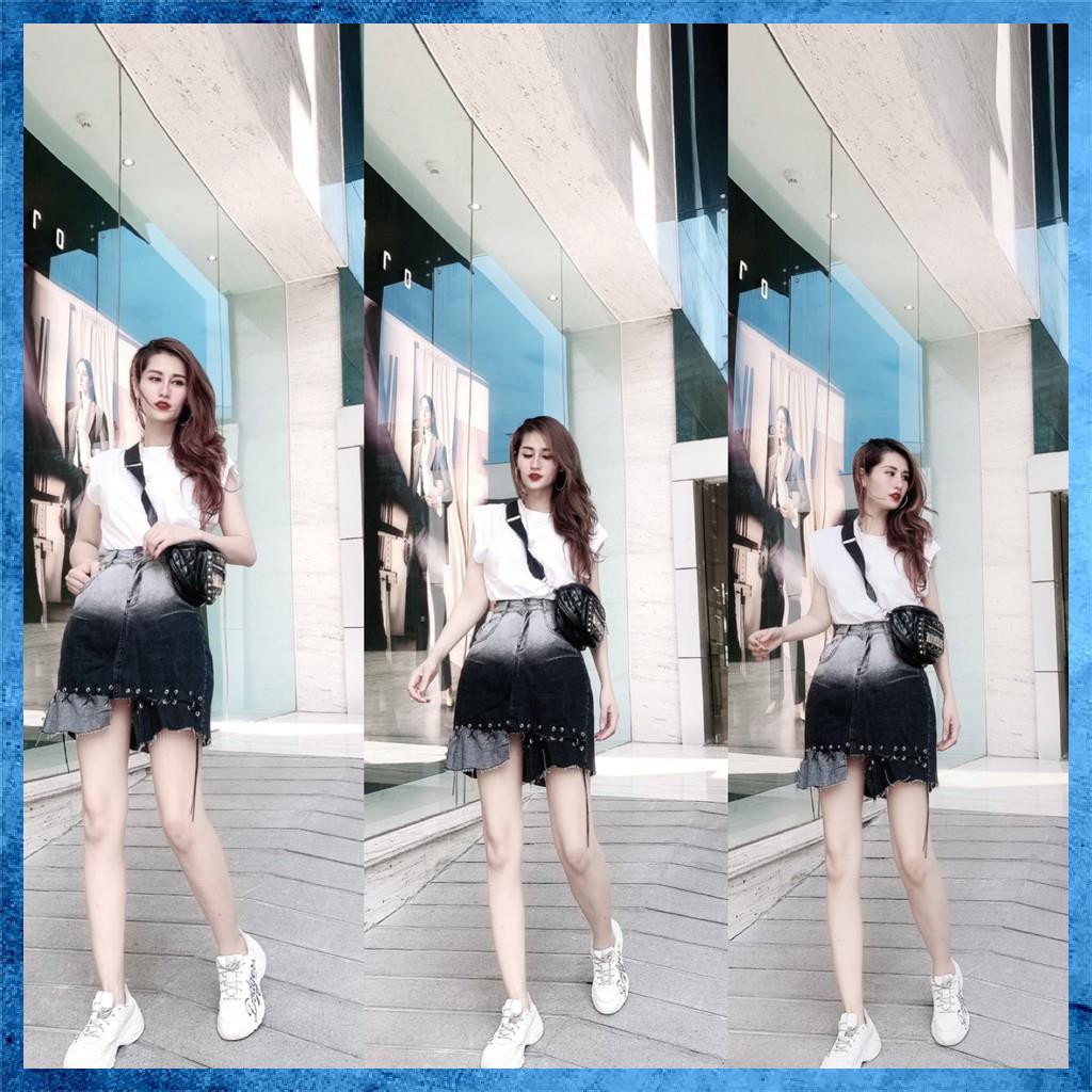Chân váy denim ngắn, cạp cao loang màu túi chéo, gấu đan dây. Mã V9135