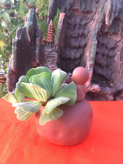 Chú tiểu ngồi trên tảng đá có thể cắm hoa , cắm bút