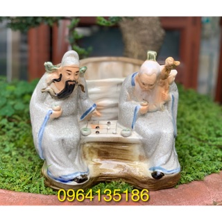 Tượng hai tiên ông đánh cờ bên chậu trồng cây gốm sứ Bát Tràng