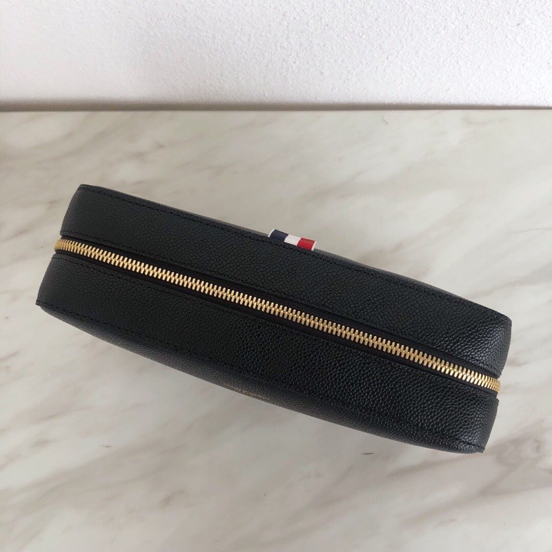 Túi clutch mới làm bằng da bò vân bóng. Thương hiệu này luôn giữ được sự chú trọng và hấp dẫn thom browne