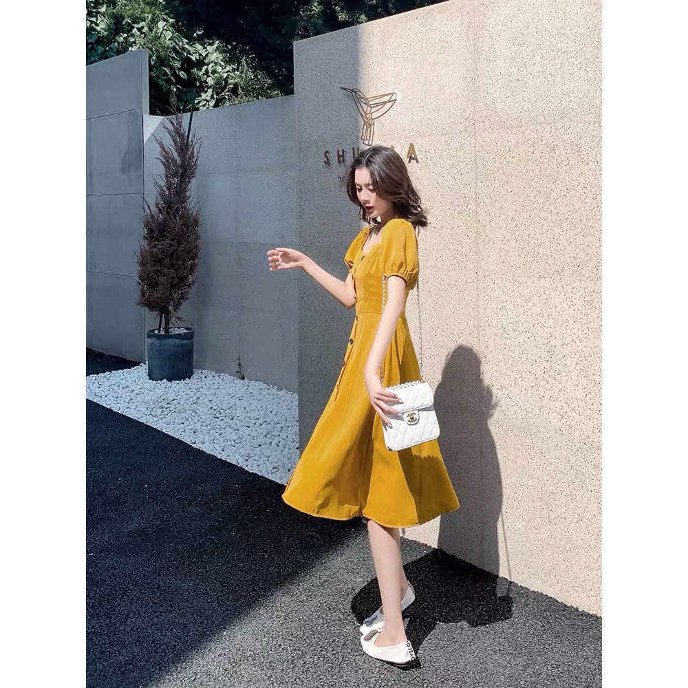 Đầm vàng bẹt vai phối nút xinh MAGB2606203