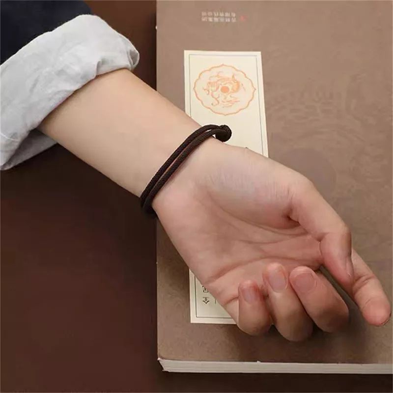 Vòng tay nam nữ dây dù cao cấp hai màu đen và đỏ có thể điều chỉnh khi đeo.