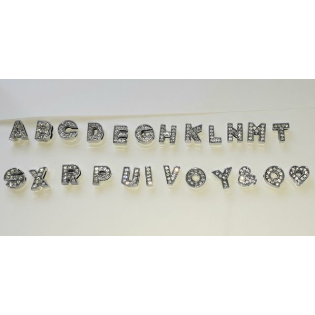 Một cái mặt chữ cái đính đá bằng thép không gỉ dùng làm trang vòng tay hoặc cổ
