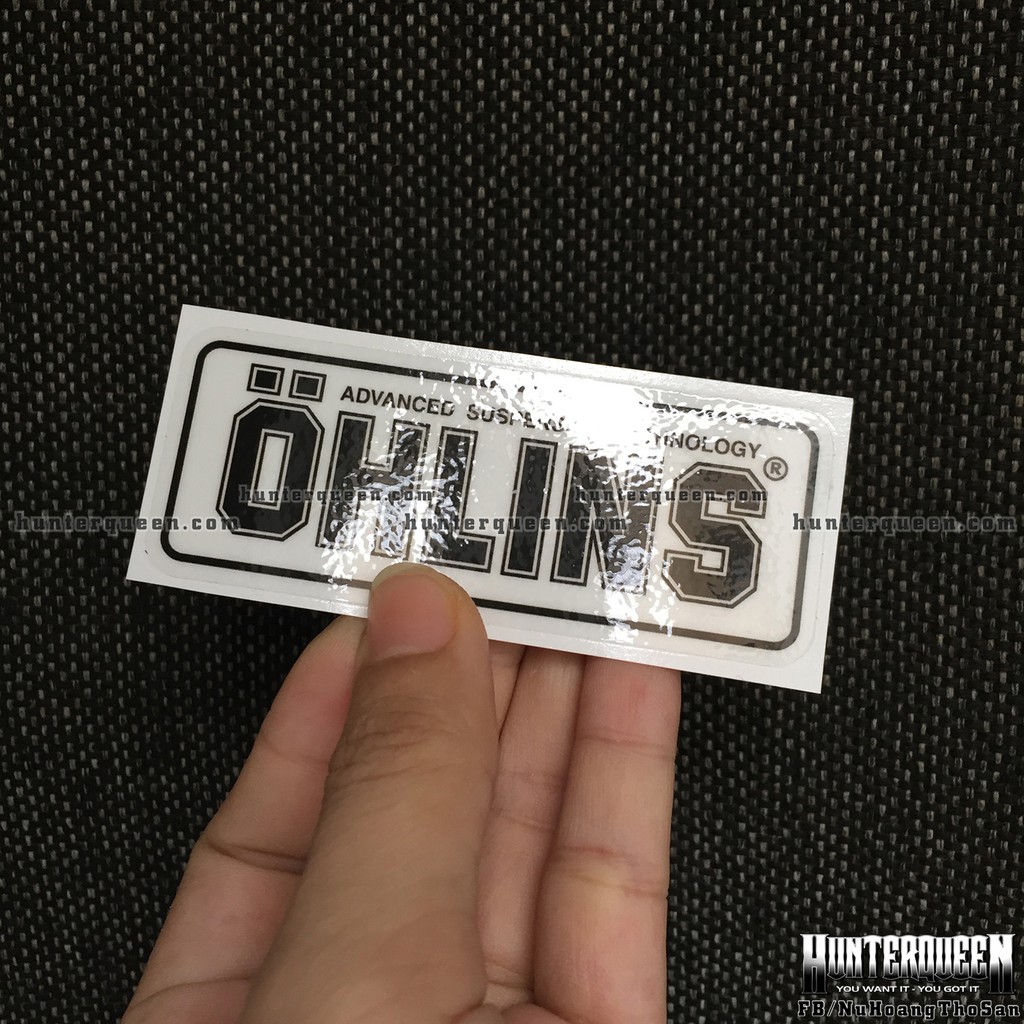 Logo Oh-Lins[9x3.7cm] trong suốt. Nền xuyên thấu, chữ đen. Hình dán decal siêu dính, chống nước, tem đua trang trí