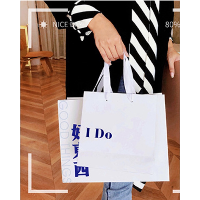 Túi giấy bìa cứng trắng logo "I DO" và "LUCK" màu xanh, quai vải mềm