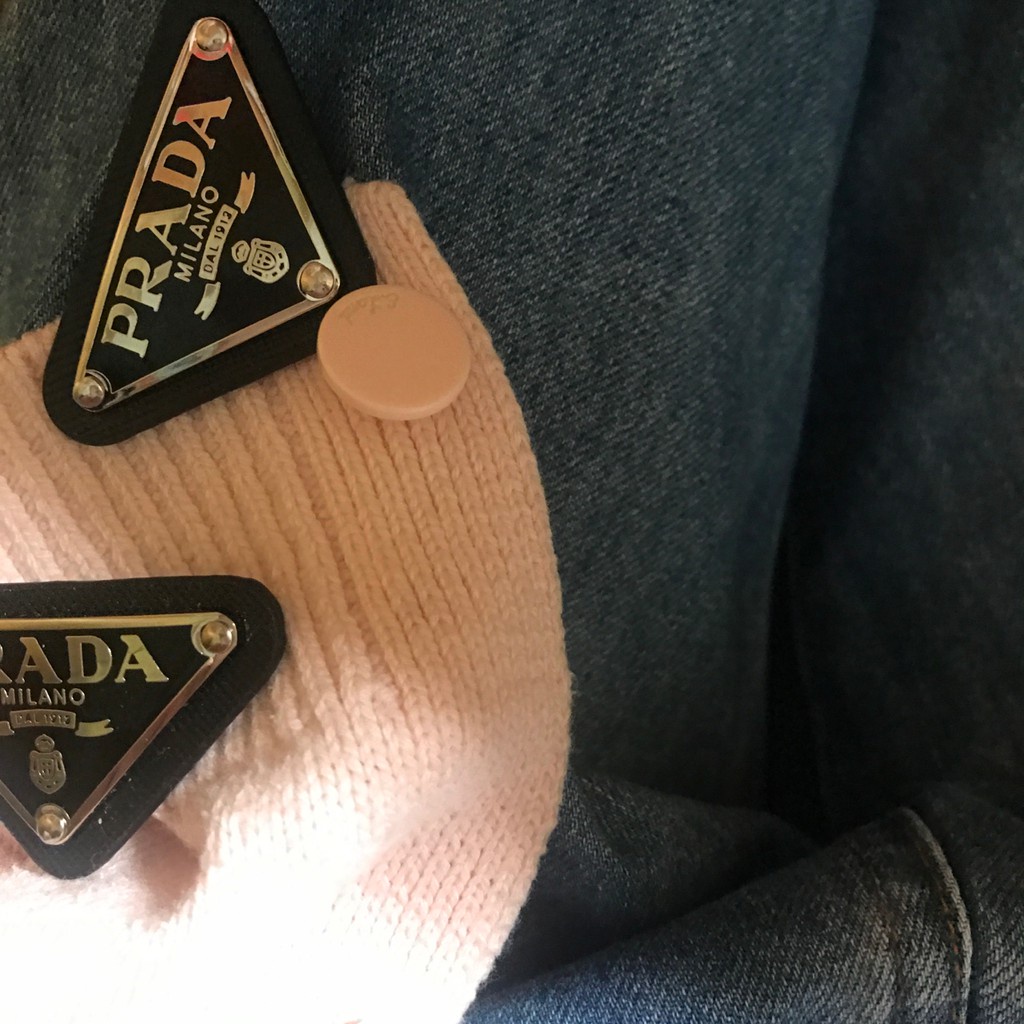 Ghim cài áo hình tam giác biểu tượng Prada dùng để trang trí