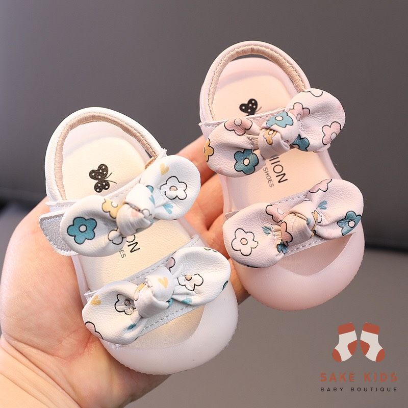 Sandal tập đi chống vấp phối nơ hình Bông hoa mũi có đế chống trơn trượt kiểu dáng Hàn Quốc mới nhất M865