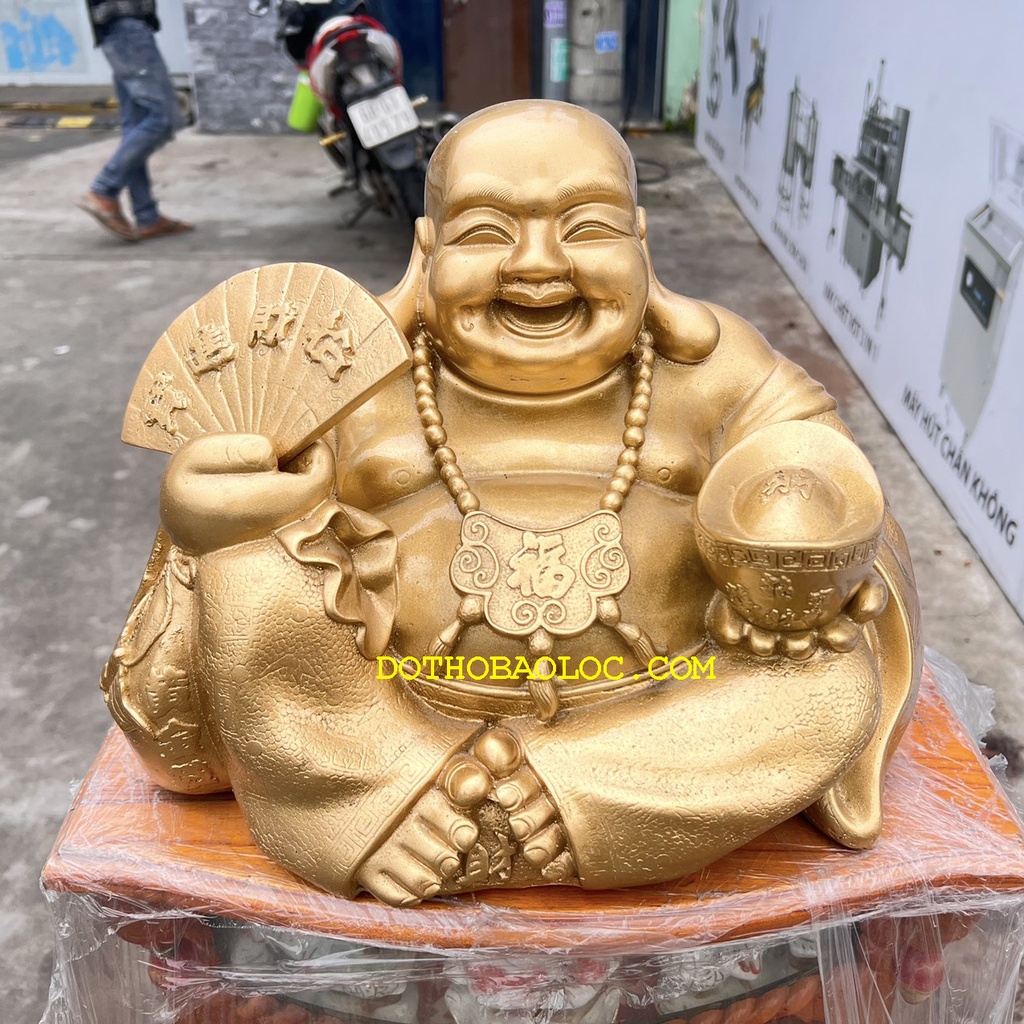 Tượng Di Lặc bột đá màu vàng đồng tay cầm quạt và thỏi vàng cao 25cm