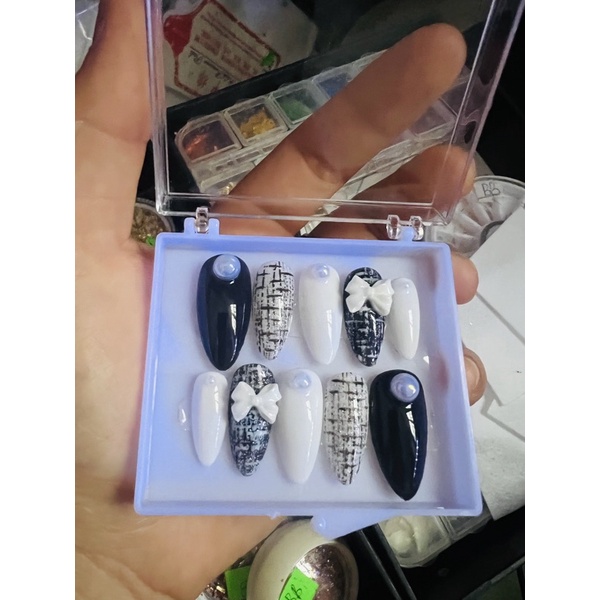 Nail box thiết kế màu đen gắn nơ kèm keo và dũa.