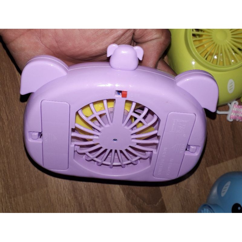 Một chiếc quạt để bàn mini bằng nhựa có dây đeo tặng kèm pin
