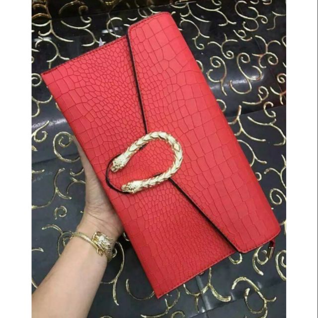 🥰 Ví cầm tay đầu rồng tông màu đỏ nổi bật.