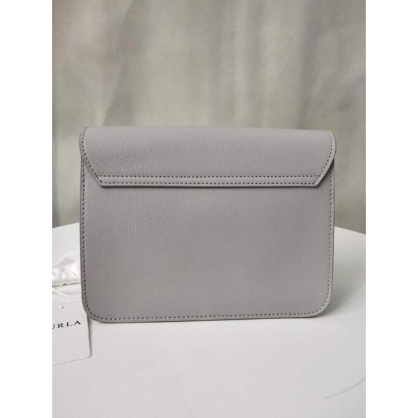 Túi đeo chéo nữ FURLA METROPOLIS  chi tiết chuẩn, từ đường keo mũi chỉ đến logo khắc đều sắc nét. Size 21cm