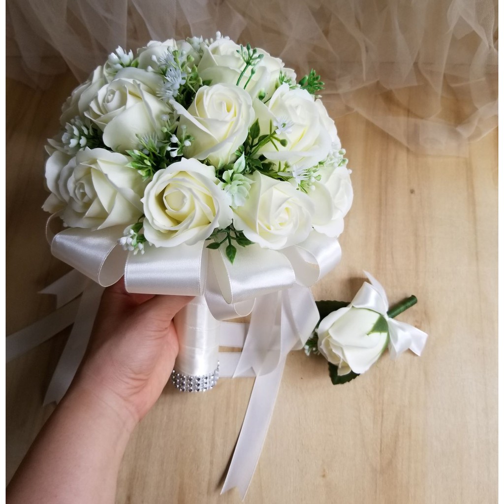 Bó hoa cưới cô dâu cầm tay hoa hồng sáp tông màu kem pastel. Tặng kèm hoa cài áo chú rể