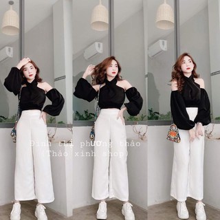 Áo sơ mi xoắn đen, quần trắng cạp cao kéo khoá