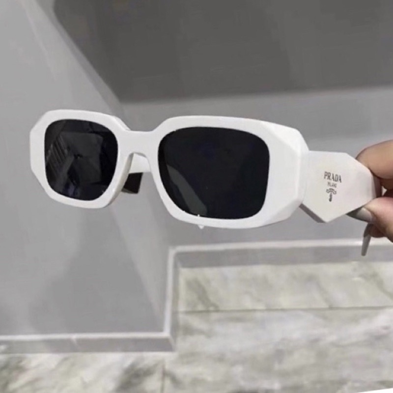 Kính râm Pra Da 2 màu đen trắng hot trend.Kiểu dáng unisex,phong cách hiện đại,sành điệu.Bản có logo 2bên,chống UV400