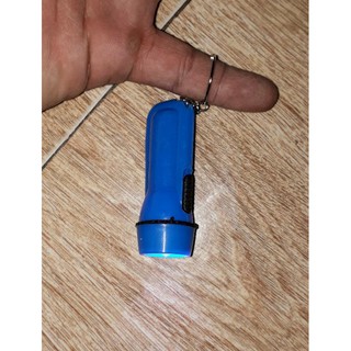 Một cái đèn pin mini làm móc khóa bằng nhựa có sẵn pin