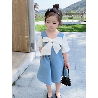 Váy bò nơ trắng form thụng bé gái