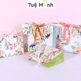 Túi đựng quà giấy hoa hình chữ nhật nằm kèm ruy băng thắt nơ đẹp mắt