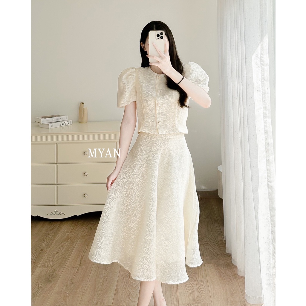 Set Áo Croptop Chân Váy Gấm Dập Nổi Myan Thiết Kế Áo Tay Bồng 4 Cúc Dọc Thân Chân Váy A Dáng Dài 2 Lớp Màu Kem Svn102202