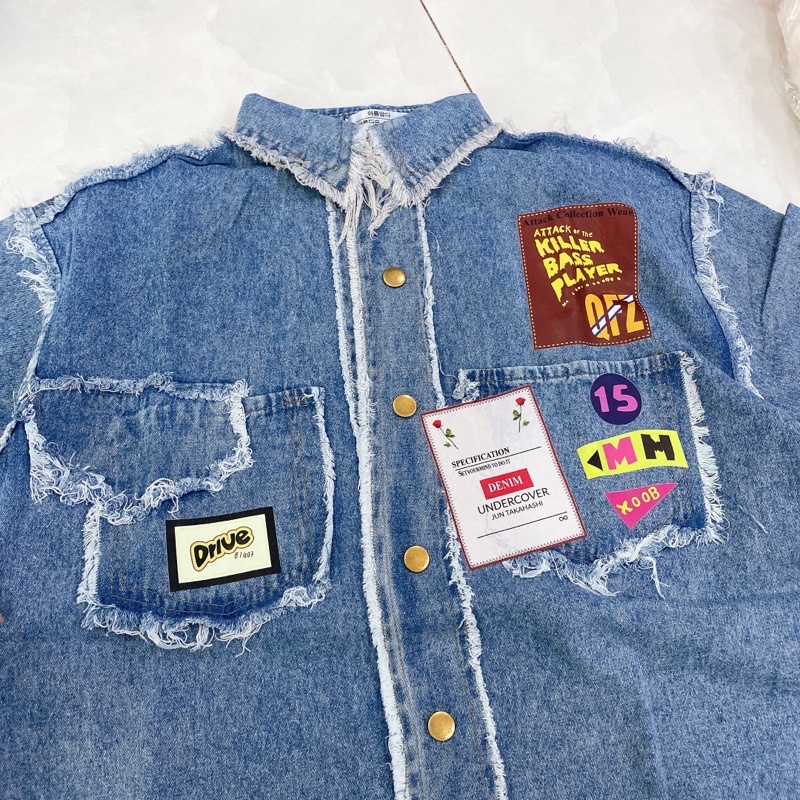 Áo sơ mi jean phối viền tua rua gắn mác chữ tay ngắn