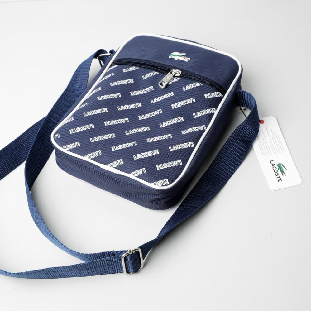 TÚI CHÉO NAM LA COS TE Logo Graphic,màu xanh navy, logo kim loại - mặt trước in chữ Lacoste, đẹp tinh tế  xịn