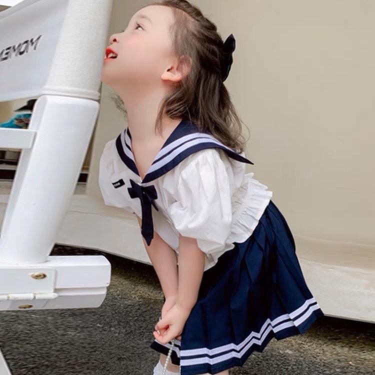 Set áo sơ mi cổ đính nơ và chân váy xếp ly đi học cho bé