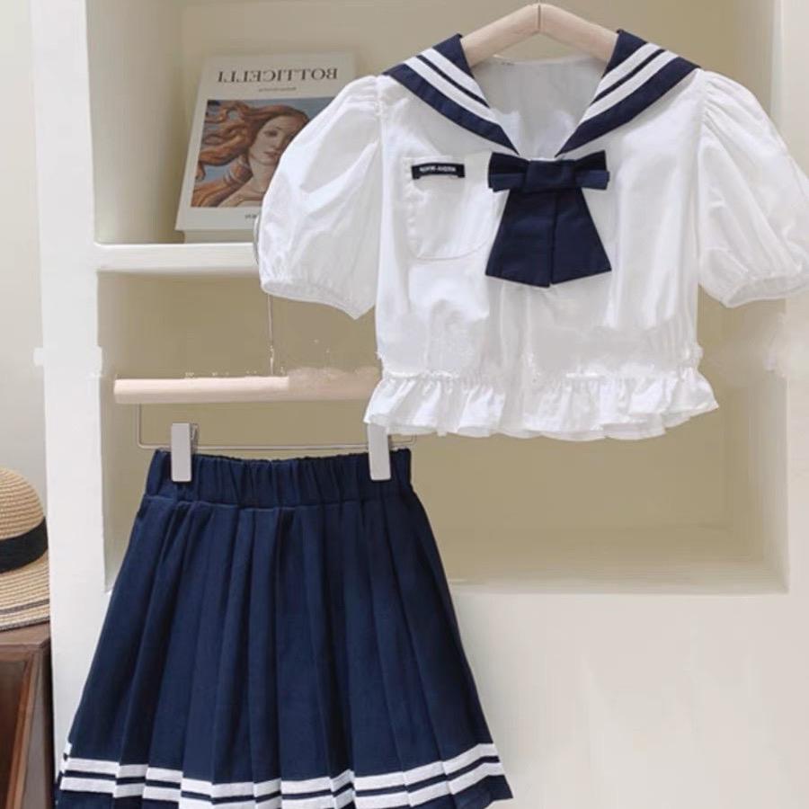 Set áo sơ mi cổ đính nơ và chân váy xếp ly đi học cho bé