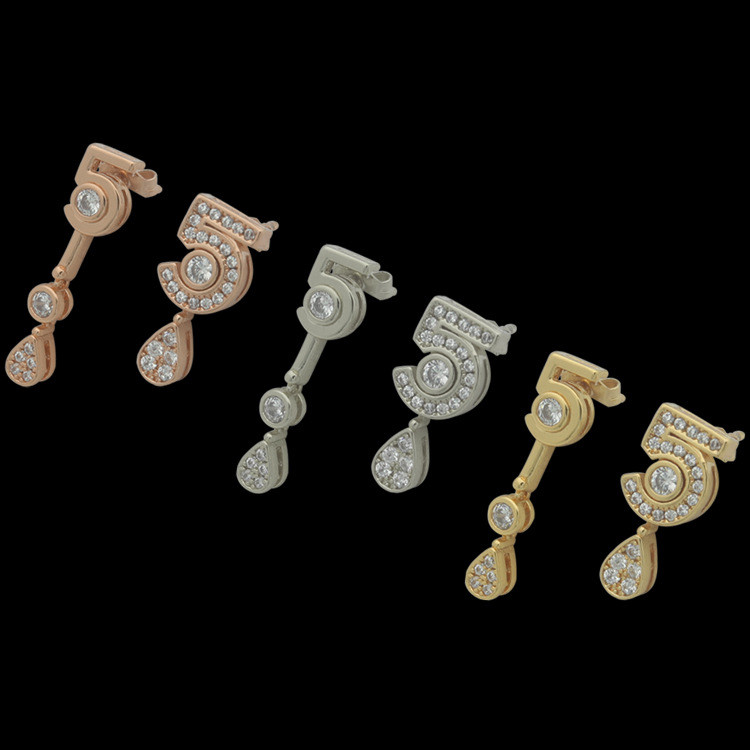 FOQU 5A woman wearing a pair of earrings with a pendant drop design and full diamond embellishments 