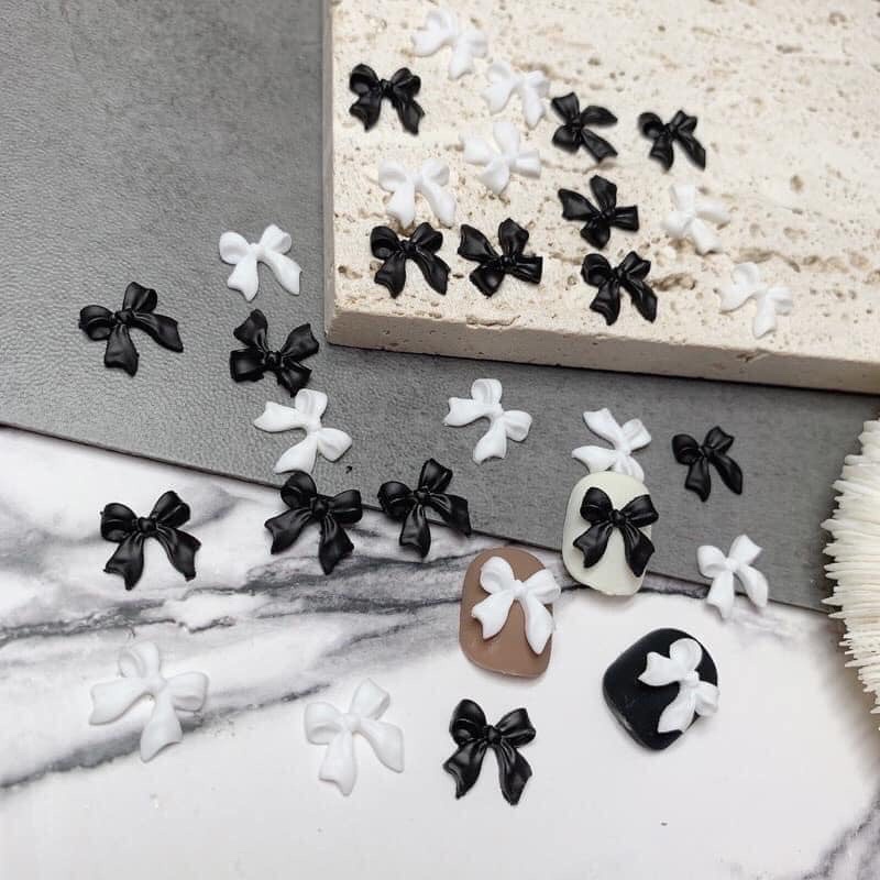 Charm nơ nhựa đen trắng đính móng sét 50 cái