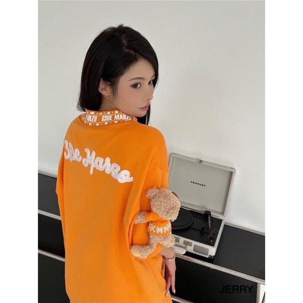 Áo phông 13de marzo cam tay đính gấu bông