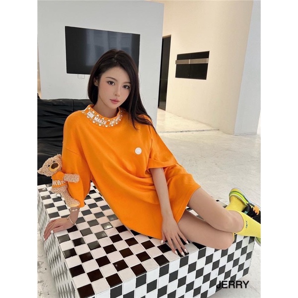 Áo phông 13de marzo cam tay đính gấu bông