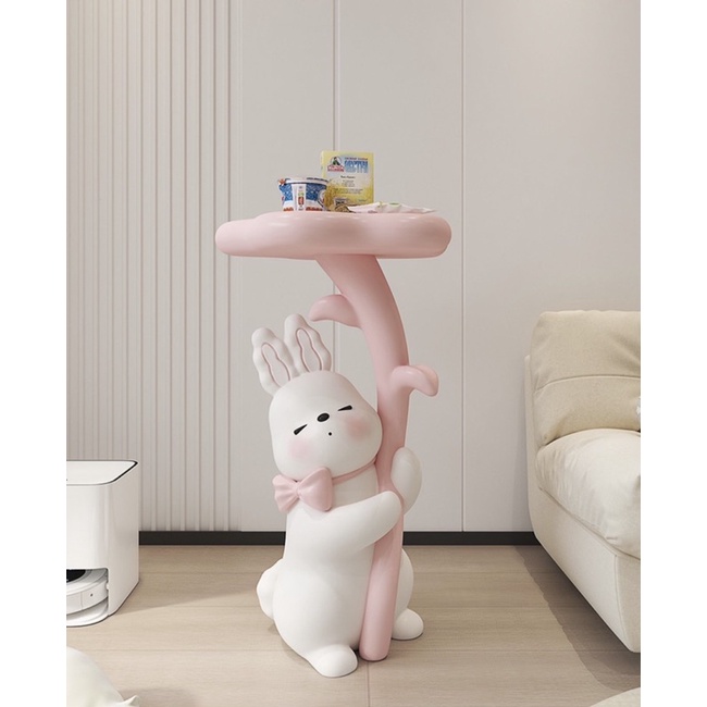 Tượng thỏ thắt nơ ở cổ ôm bông hoa kết hợp làm bàn trang trí nhà cửa kiểu dáng đáng yêu