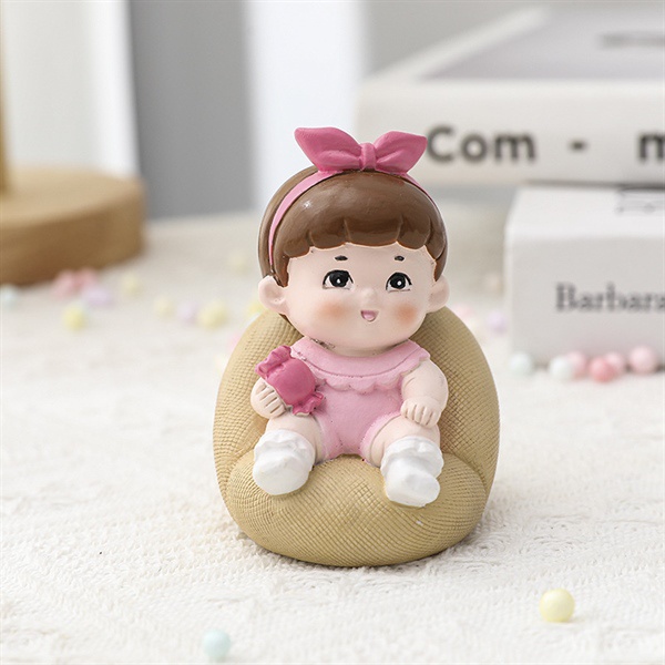 Trang trí bé gái ngồi ghế sofa hồng SỨ