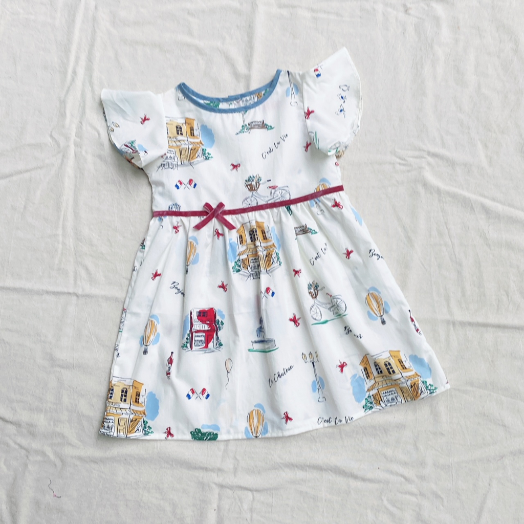 Đầm bé gái nơ eo họa tiết Paris và lá cam