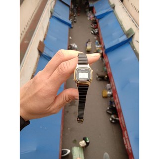 Đồng hồ nữ casio mặt đen viền vàng.