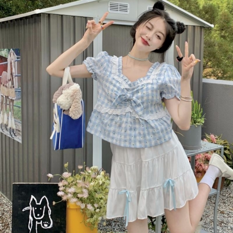 Áo croptop kiểu kẻ caro xanh và quần đùi trắng đính nơ điệu đà