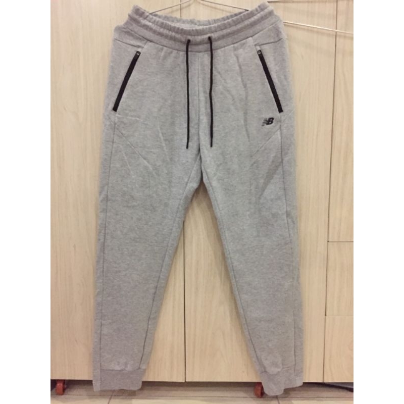 Quần jogger New Balance xuất dư màu xám, túi khóa kéo.
