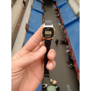 Đồng hồ nữ casio mặt đen viền vàng.