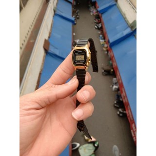 Đồng hồ nữ casio mặt đen viền vàng.