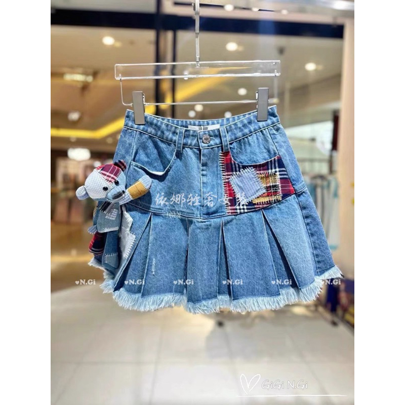 Chân váy jeans 13de marzo xếp ly đính gấu bông đáp vải kẻ đỏ