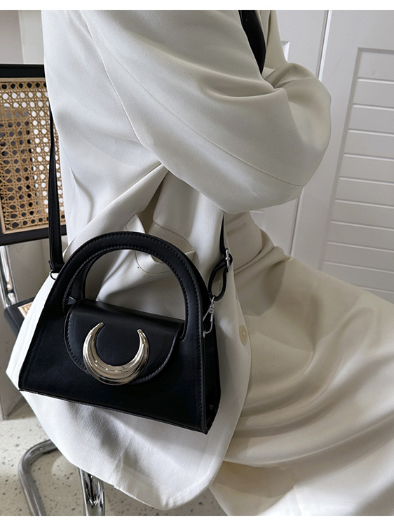 Túi xách nữ đeo chéo kiểu dáng thời trang với chi tiết trang trí hình trăng khuyết, có hai màu đen và tím