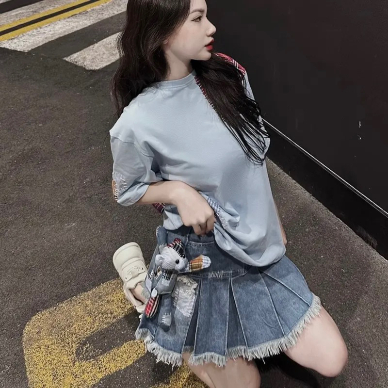 Chân váy jeans 13de marzo xếp ly đính gấu bông đáp vải kẻ đỏ