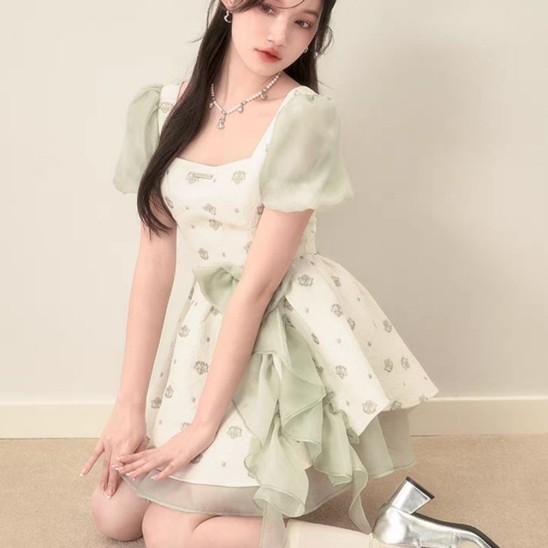 Váy xòe xốp trắng phối hoa nơ tua rua xanh