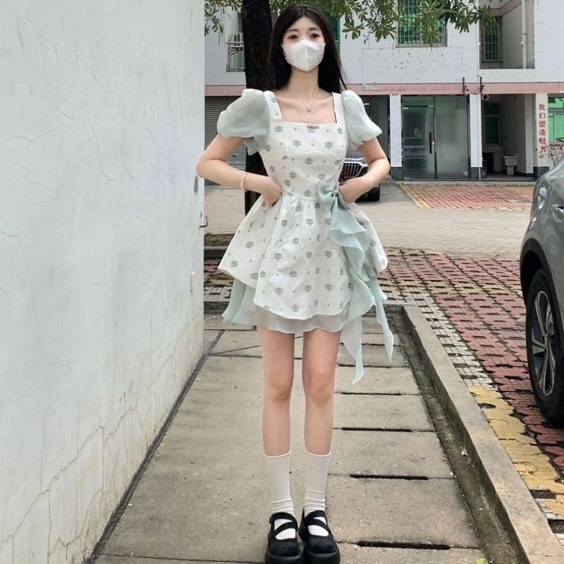 Váy xòe xốp trắng phối hoa nơ tua rua xanh