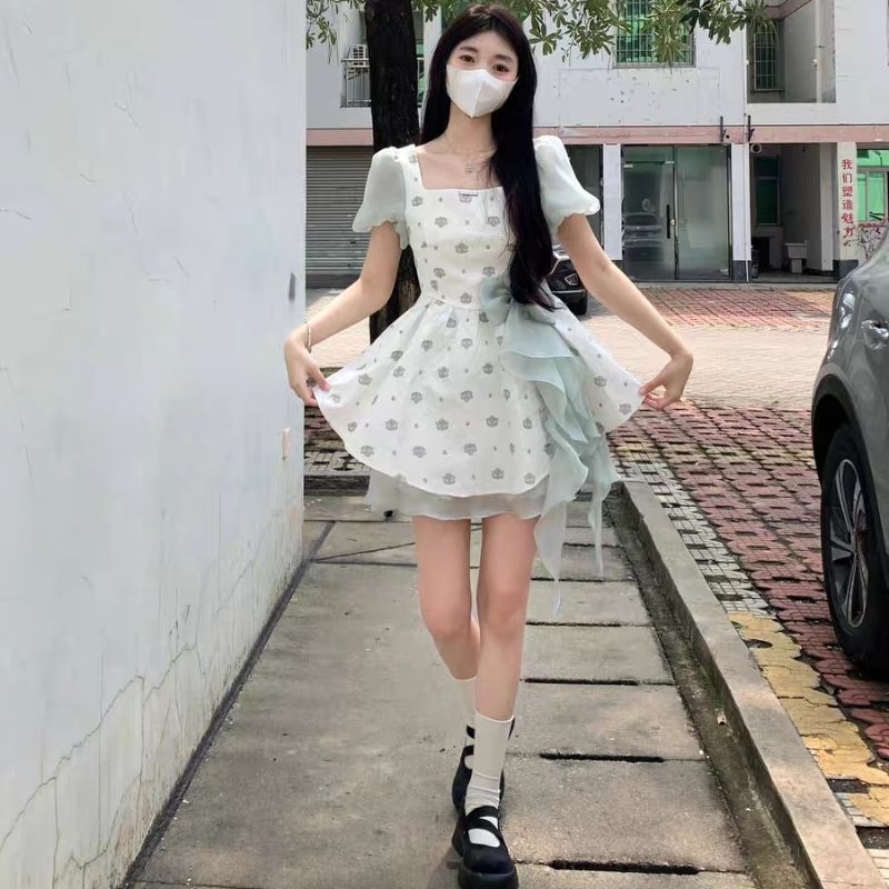 Váy xòe xốp trắng phối hoa nơ tua rua xanh